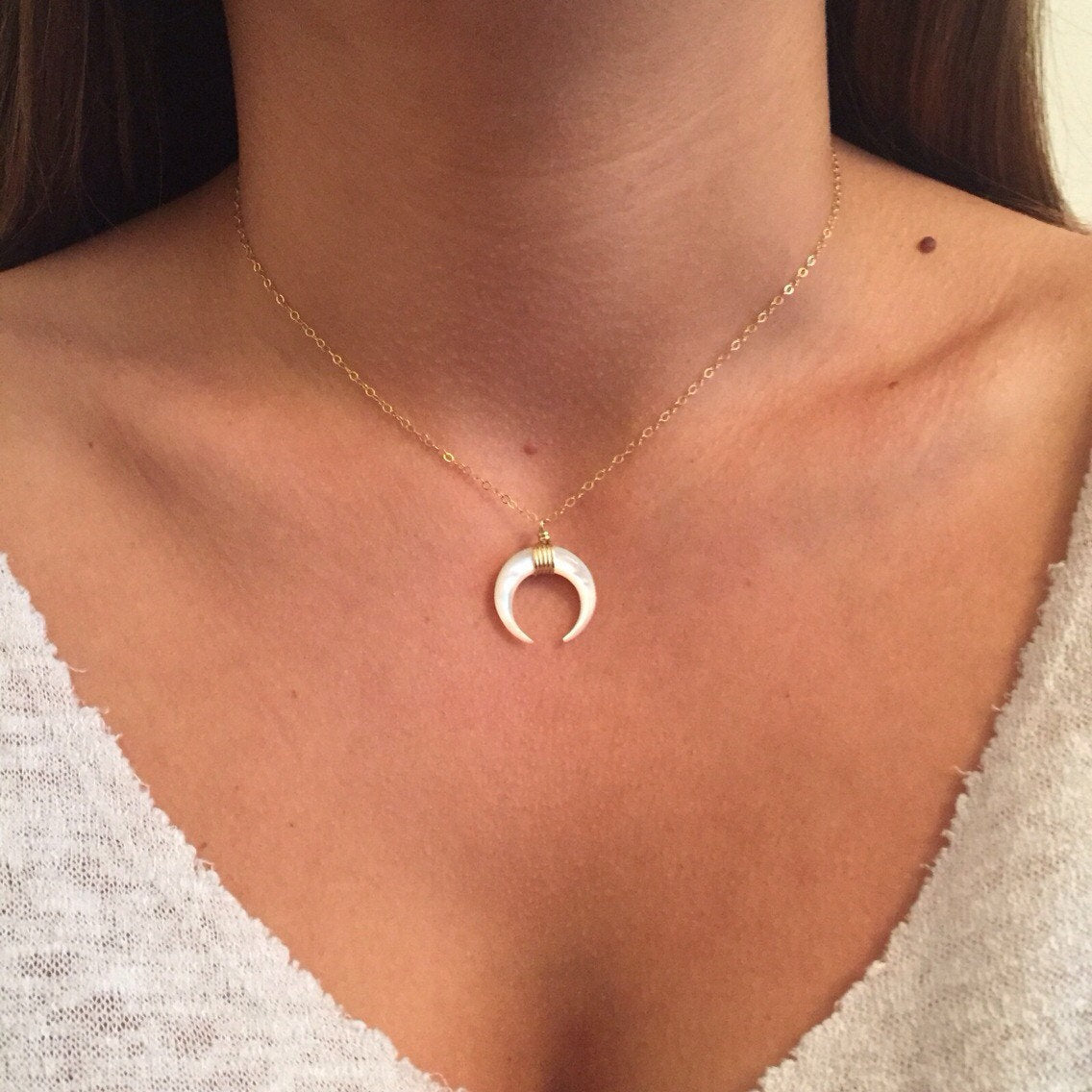 Short necklace with a crescent moon pendant.